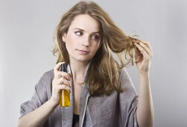 Beautiful curly blonde takes care of her hair — Stock Photo, Image