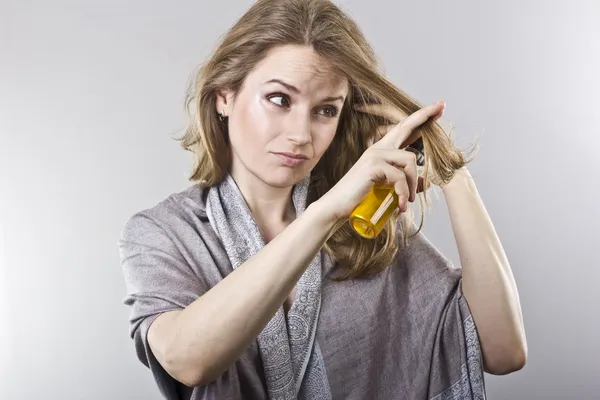 Beautiful curly blonde takes care of her hair — Stock Photo, Image