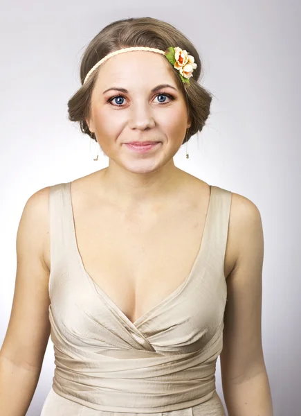 Vacker härlig tjej med en blomma på hennes huvud — Stockfoto