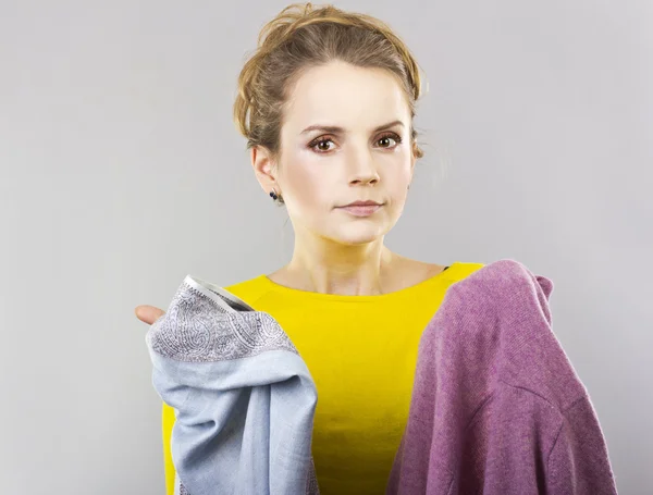 Jovem loira com roupas nas mãos — Fotografia de Stock