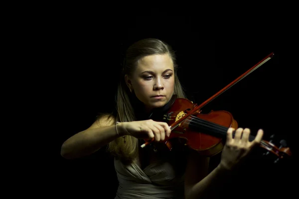 Beautiful blue-eyed girl playing the red violin in the dark — Stock Photo, Image