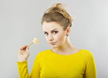 güzel sarışın gri bir arka plan üzerinde elinde bir çiçek