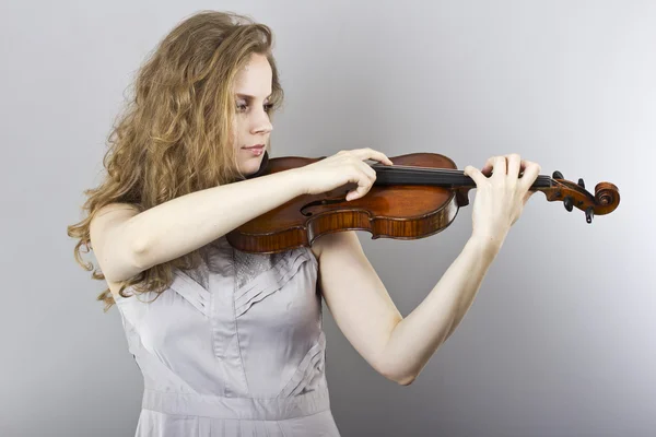 Belle jeune femme blonde en robe de soirée grise avec violon rouge — Photo