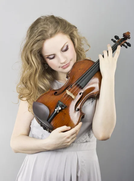 Hermosa joven rubia en vestido de noche gris con violín rojo —  Fotos de Stock