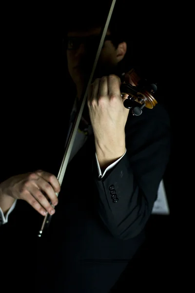 Piękna brunetka gra gry na skrzypcach w ciemności — Zdjęcie stockowe