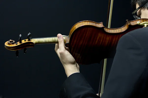 Mooie brunette speelt de viool in het donker — Stockfoto