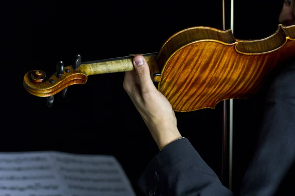 Schöne Brünette spielt Geige im Dunkeln — Stockfoto