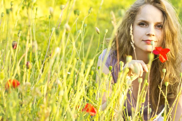 美丽而快乐的女孩，享受着阳光的罂粟田。在户外的女人。在头发中的曙光。乡村风格。花卉场。自由幸福的女人 — 图库照片