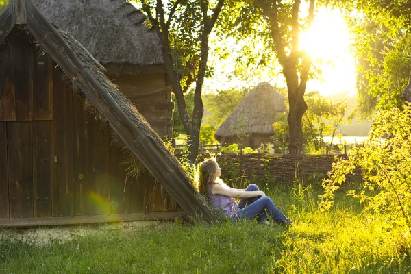 Linda loira encaracolada gosta do sol no campo. Raios de sol no cabelo. Estilo country. Casa de campo. tempo perfeito . — Fotografia de Stock