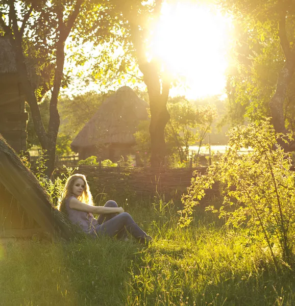 Beautiful curly blonde enjoys the sun in the countryside. Sunrays in the hair. Country style. Country house. perfect weather. — Stock Photo, Image