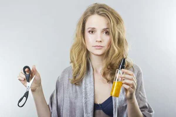 Beautiful curly blonde takes care of her hair. — Stock Photo, Image