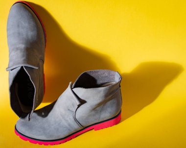 Sarı arka planda bir çift şık ayakkabı.