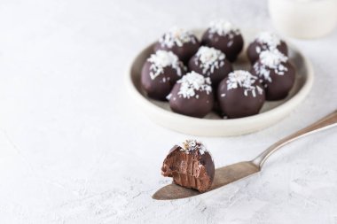 Hafif arka planda hindistan cevizi taneli çikolatalı trüf. Şeker, glüten ve laktozsuz sağlıklı yiyecekler..