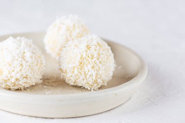 Hafif arka planda beyaz çikolatalı hindistan cevizli mantarlar. Şeker, glüten ve laktozsuz vejetaryen.