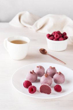 Beyaz tabakta ahududulu ev yapımı trüf mantarı. Şeker, glüten ve laktozsuz vejetaryen.