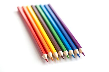 Beyaz bir arka plan üzerinde üst üste çok renkli kalemler.