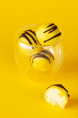 Bardakta sarı çikolatalı vegan trüf mantarı. Şeker, laktoz ve glütensiz.