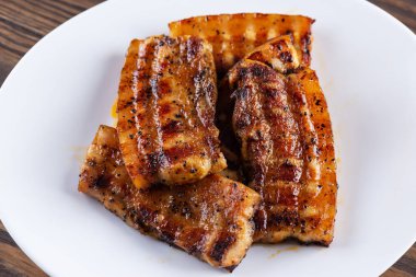 Beyaz tabakta ızgara domuz pastırması..