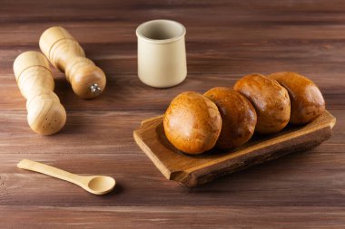 Kahverengi bir masada, ahşap bir tabakta pişmiş turtalar..