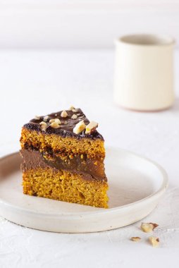 Beyaz tabakta portakallı, çikolatalı ve cevizli vejetaryen kabak turtası. Şeker, glüten ve laktozsuz.