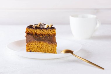 Beyaz tabakta çikolatalı, portakallı ve fındıklı Amerikan balkabağı turtası. Şeker, glüten ve laktozsuz vejetaryen.