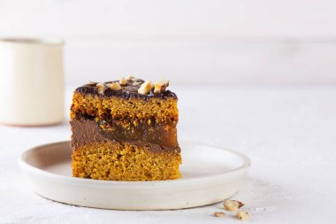 Tabağında fındık olan bir parça çikolatalı kabak turtası. Şeker, glüten ve laktozsuz vejetaryen. Yatay yönelim, boşluğu kopyala.
