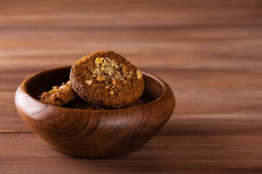 Tahta bir kasede fındıklı ev yapımı yulaf ezmeli kurabiyeler. Şeker, glüten, laktozsuz, vejetaryen. Yatay yönelim, boşluğu kopyala.