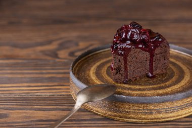Kahverengi ahşap bir masada siyah üzümlü ve patlıcanlı çikolatalı kek. Şeker, glüten, laktozsuz, vejetaryen.