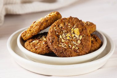 Quinoa, fındık, yulaf ezmesi ve hafif arkaplanda havuçtan yapılan ev yapımı kurabiyeler. Şeker, glüten ve laktozsuz vejetaryen.