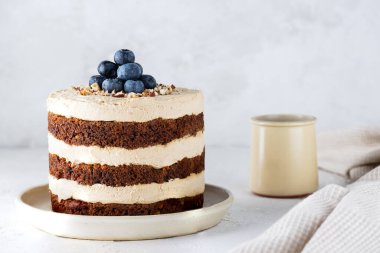 Yabanmersini ve fındıkla süslenmiş ev yapımı havuçlu kek. Şeker, glüten ve laktozsuz vejetaryen.