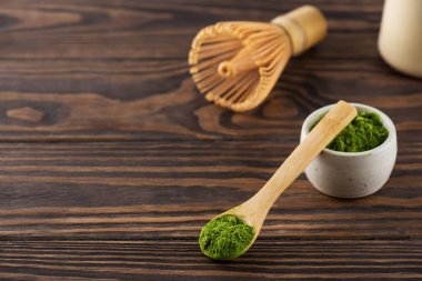 Tahta bir masada çırpıcıyla kaşıkta kibrit çay tozu. Yatay yönelim, boşluğu kopyala.