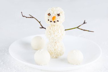 Beyaz tabakta hindistan cevizli mantardan yapılan kardan adam. Şeker, glüten ve laktozsuz vejetaryen.