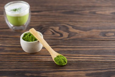 Tahta bir masada kaşıkta kibrit çay tozu. Yatay yönelim, boşluğu kopyala.