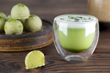 Tahta bir masada mantarlı bir bardakta kibrit latte çayı. Şeker, glüten ve laktozsuz vejetaryen.