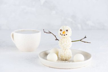 Hindistan cevizli mantardan yapılmış tatlı kardan adam ve bir fincan kapuçino kahvesi. Şeker, glüten ve laktozsuz vejetaryen.