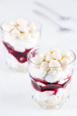 Aquafaba kremalı vejetaryen tatlı, hindistan cevizi kreması ve kirazlı masada bir bardak. Şeker ve laktozsuz.