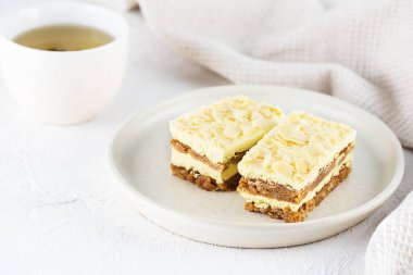 Dilimlenmiş limonlu kek ve masada bir fincan çay..