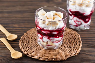 Aquafaba kremalı ev yapımı tatlı, hindistan cevizi kreması ve ahşap bir masada vişneli. Şeker, laktozsuz, vegan.