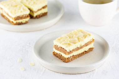 Tabakta badem olan limonlu pasta ve masada bir fincan çay. Şeker, glüten ve laktozsuz vejetaryen.