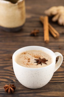 Süt ve baharatla ahşap bir masada Hint masalı çay..