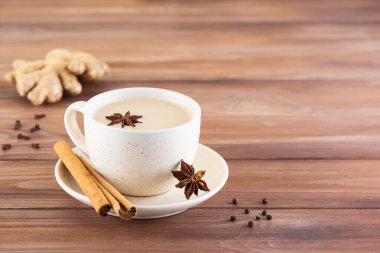 Hindistan Masala çayı, hindistan cevizi sütü, anason, tarçın, zencefil, biber ve ahşap bir masada. Seçici odak.