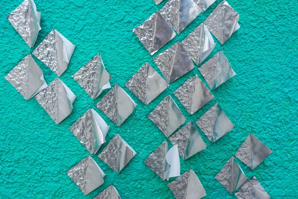 Paper silver on green wall — Stock Photo, Image