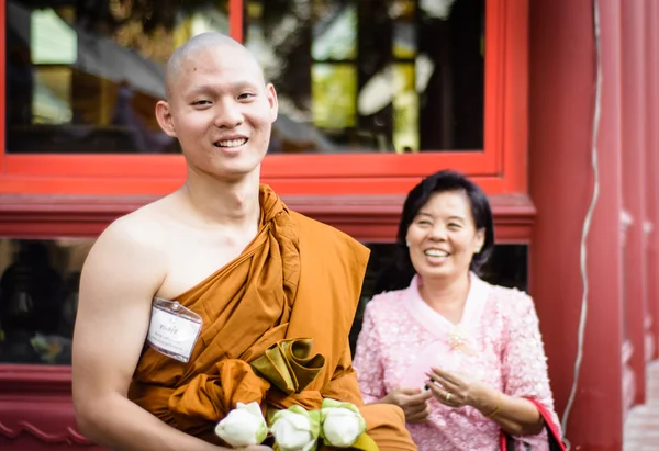 Familie in buddhistischer Ordinationszeremonie Stockbild