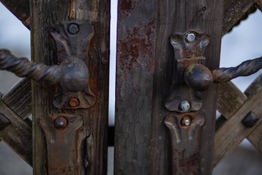 Eski, paslı demir kilitler ve demirci tarafından dövülmüş eski bir ahşap kapı.