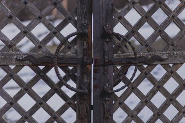 Eski, paslı demir kilitler ve demirci tarafından dövülmüş eski bir ahşap kapı.