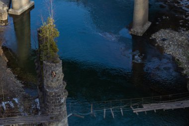 Eski ahşap harabe köprü Yaremche Ukrayna Karpatları 'nın hızlı nehri üzerinde bahar başlarında çekilmiş bir fotoğraf.