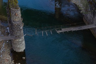 old wooden ruined bridge over a mountain fast fast river in Yaremche Ukraine Carpathians mountains photo taken in early spring