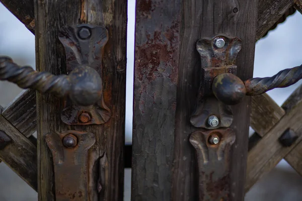 Eski, paslı demir kilitler ve demirci tarafından dövülmüş eski bir ahşap kapı.