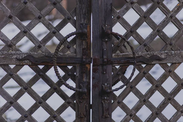 Eski, paslı demir kilitler ve demirci tarafından dövülmüş eski bir ahşap kapı.