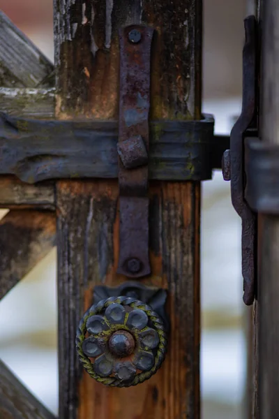 Eski, paslı demir kilitler ve demirci tarafından dövülmüş eski bir ahşap kapı.